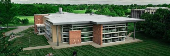 Overhead drone shot of CAER Lab 2: a large, low-slung building made of bricks with windows that almost take up the entire side